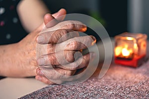 Hands of an old woman folded for prayer.