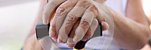 Hands of old woman holding walking cane