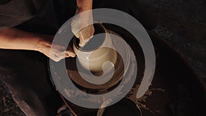 Hands of an old woman making a clay pot in the workshop