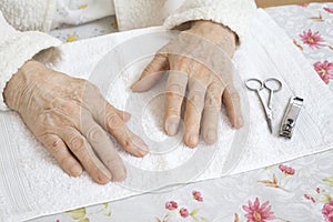 Hands of an old woman prepared for a cosmetic treatment.