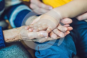 Hands of an old woman and a young man. Caring for the elderly. c