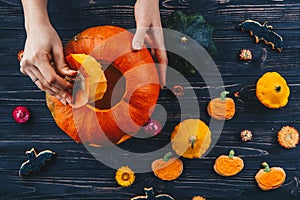 Hands opening Halloween pumpkin on celebrate wooden table Trick or Treat horizontal view from above