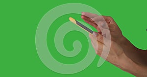 Hands operating mobile phone with touchscreen on green background