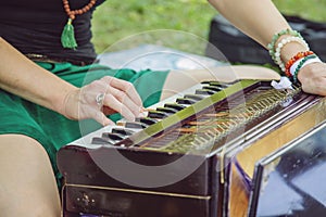 hands outdoor playing on Shruti box music instrument