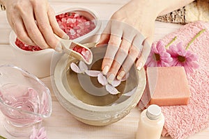 Hands over ceramic bowl with water and essential oils