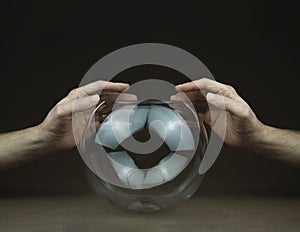 hands over transparent glass ball