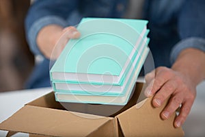 hands packing books into box