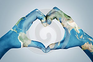 Hands, painted in the world map,  forming heart shape