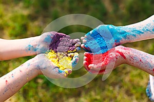 Hands Palms of young people covered in purple, yellow, red, blue Holi festival colors isolated