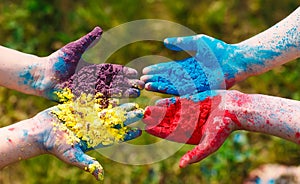Hands Palms of young people covered in purple, yellow, red, blue Holi festival colors isolated.