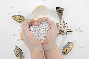 Hands with pearl beads and seashells