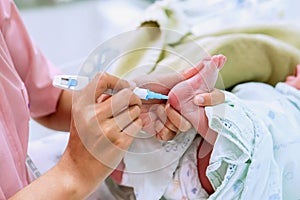 Hands of pediatric nurse holding and using Accu-Chek Fastclix