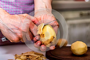 Hands peeling potatoes close