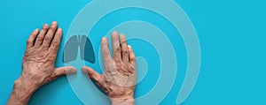 hands of a pensioner and the symbol of the organ lungs on a blue background, banner, copyspace on the right. the concept of