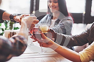 Hands of people with glasses of whiskey or wine, celebrating and toasting in honor of the wedding or other celebration