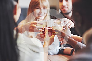 Hands of people with glasses of whiskey or wine, celebrating and toasting in honor of the wedding or other celebration