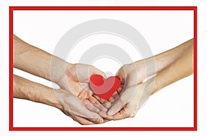 The hands of people hold a red heart in a red frame. Valentines day relationship concept. On isolated background