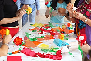 Hands of people make artificial flowers