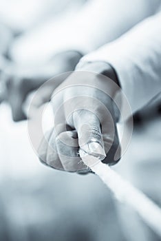 Hands of people pulling a rope as cooperation concept