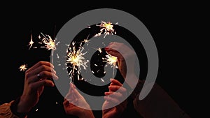 Hands of people with sparklers celebrating Christmas at night. Christmas holiday concept