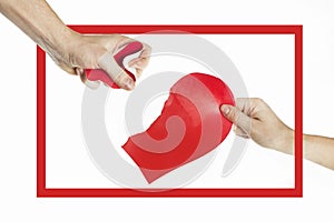 The hands of people tearing the heart apart in a red frame. Valentine`s day concept. Torn heart. On isolated background