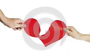 The hands of people tearing the heart apart. Valentine`s day concept. Torn heart. On isolated background