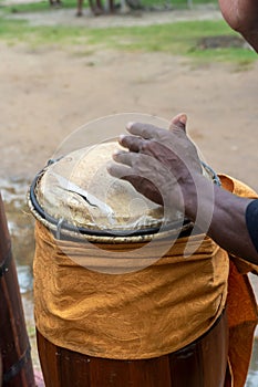 Hands of a percussionist playing atabaque at a religious event