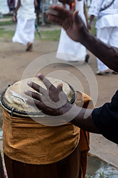 Hands of a percussionist playing atabaque at a religious event