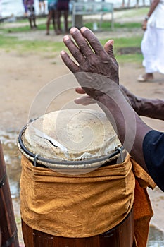 Hands of a percussionist playing atabaque at a religious event