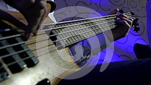 Hands performer virtuoso Bass Guitar player and quickly moves fingers on the guitar neck during concert. concept entertainment and