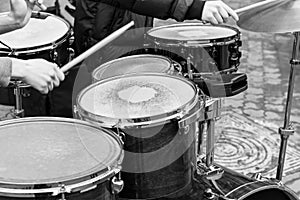 Hands of performing musicians playing drum set in street