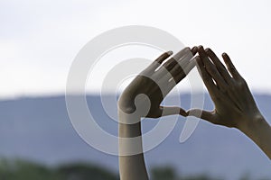 Hands of person making frame distance or symbol in nature