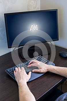 Hands of a person typing on keyboard in front of computer screen displaying AI concept