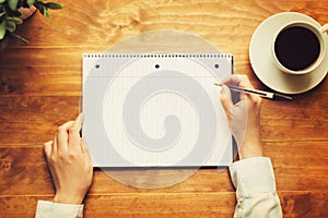 Hands of a person writing in a small notepad