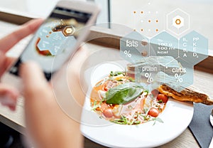 Hands with phone and food nutritional value chart