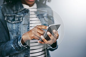 Hands, phone and woman with chat by wall background for typing email, contact or texting on internet. Student girl