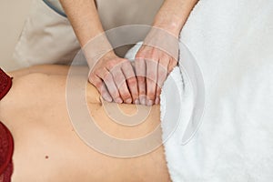 Hands of physiotherapist checking diastasis recti on belly of postpartum woman