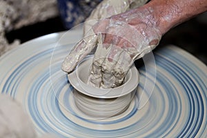 Hands on a piece of pottery made of clay