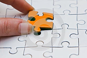 Hands placing piece of a Puzzle