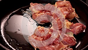 Hands placing raw poultry meat on hot frying pan. Cooking chicken on skillet.