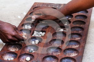 Hands playing Mancala game, Stone town, Tanzania