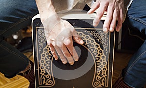 Hands playing percussion with a Flamenco box