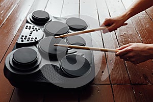 Hands playing on portable electronic drums