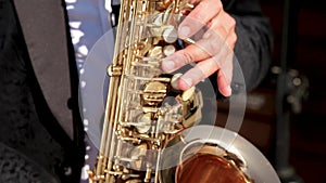 Hands playing the saxophone. Saxophonist plays jazz and love music.