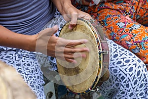 Hands playing tambourine during capoeira performance