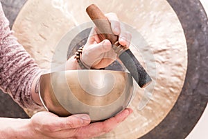 Hands playing Tibetan singing bowls