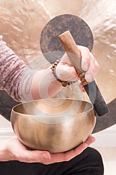 Hands playing Tibetan singing bowls