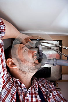 Hands of plumber assembling sink pipes