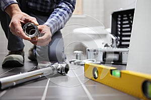 Hands plumber at work in a bathroom, plumbing repair service, as