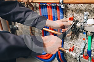 Hands of plumber working in boiler room